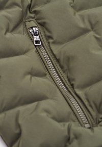 Olive green quilted vest featuring a metallic zipper, stitched pattern, and smooth texture. The zipper is positioned on the left side.