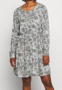 Robe longue à manches longues bleu clair avec un motif cachemire dans des nuances de marron et de blanc, dotée d'une taille élastique et d'un col rond.