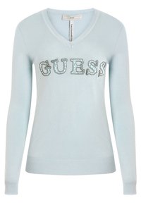 Suéter azul claro con cuello en V y mangas largas. Presenta el logo "GUESS" adornado con detalles decorativos. Puños y dobladillo con textura acanalada.