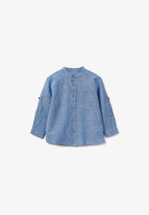 Camicia a maniche lunghe di colore azzurro chiaro con colletto alla coreana, bottoni marroni sulla parte frontale e sulle linguette delle maniche, e una tasca sul petto con bottone, su sfondo bianco.