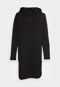 Černé mikinové šaty s kapucí vyrobené z měkké tkaniny. Obsahují klokaní kapsu a nastavitelnou šňůrku na kapuci. Na přední straně je umístěn textový logo detail.