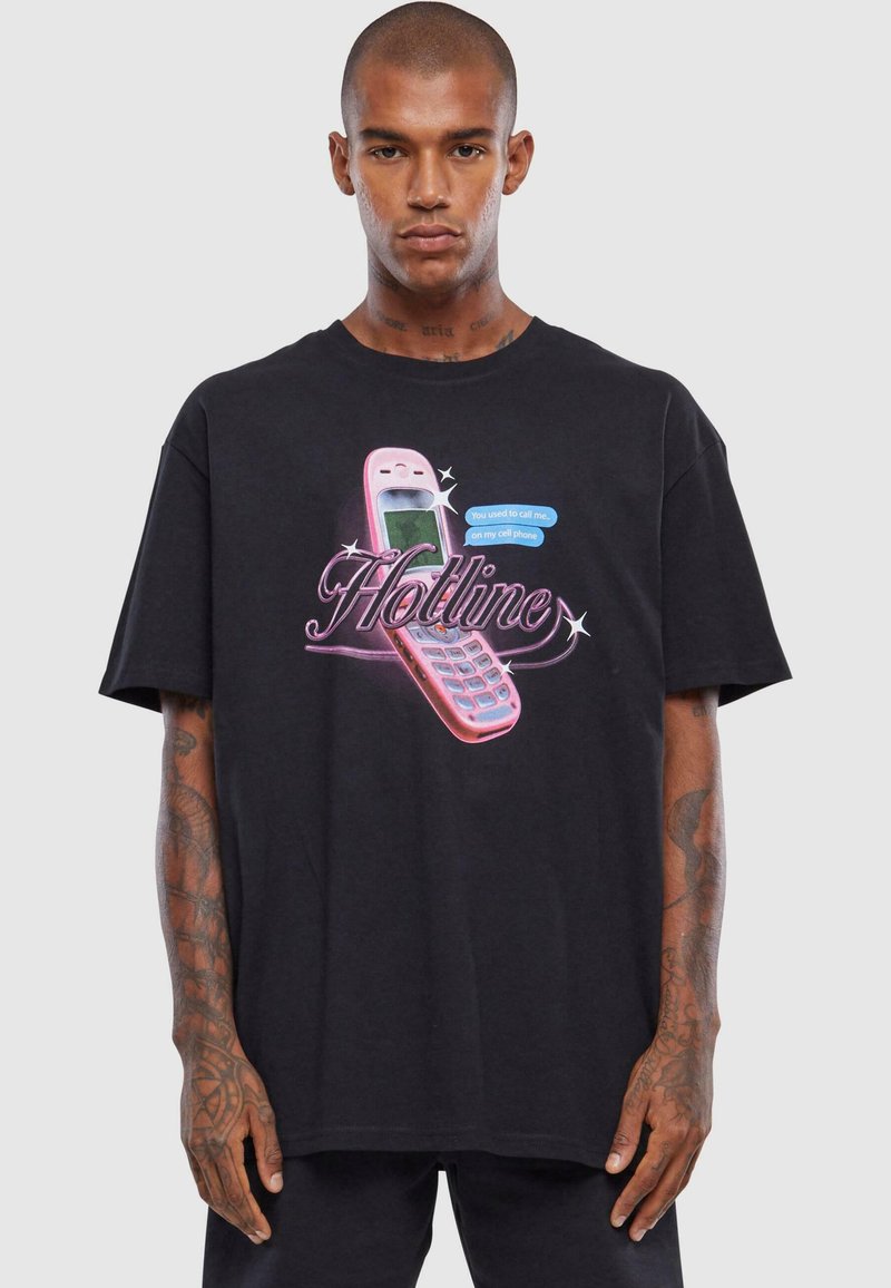 Sort t-shirt med et grafisk motiv af en pink vintage mobiltelefon og teksten "Hotline" i fed skrift. Lavet af bomuldsstof, afslappet pasform.