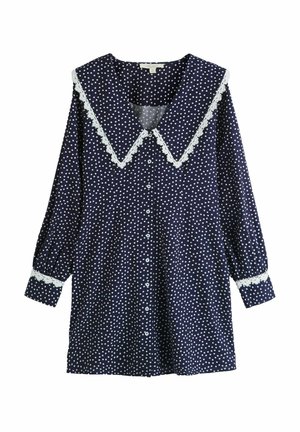 Marineblaues Langarmkleid mit weißen Polka-Dots, großem spitzem Kragen, Spitzenbesatz an Kragen und Manschetten sowie vorderer Knopfleiste.