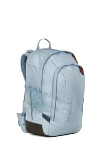 Zaino Satch di colore azzurro con più scomparti, spallacci imbottiti, tasche laterali in rete e rinforzo marrone alla base.