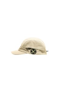Gorra beige hecha de un tejido ligero con visera curvada. Presenta un parche redondo negro con texto amarillo en el costado y una corona ligeramente curvada.