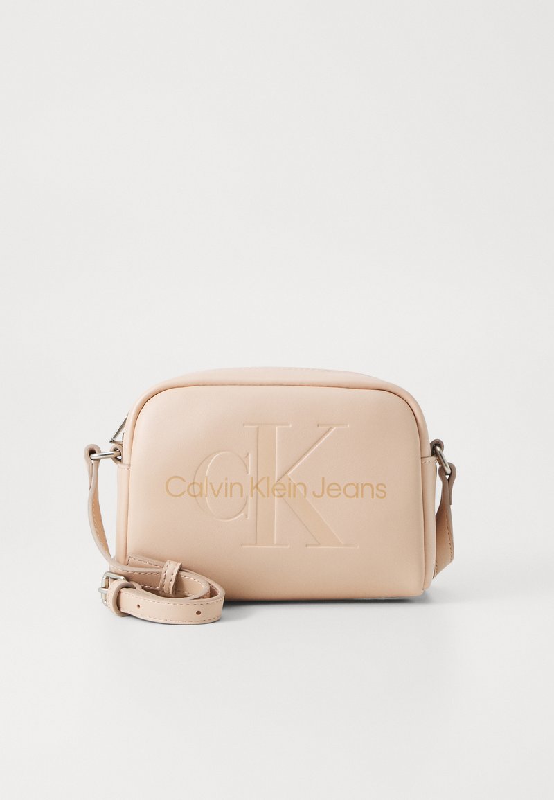 Borsa a tracolla Calvin Klein Jeans in morbida ecopelle beige chiaro. Presenta il logo impresso e una tracolla regolabile. Forma rettangolare.