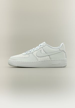 Zapatilla blanca baja Nike Air Force 1 con paneles de malla y superposiciones de cuero, vista desde un costado sobre un fondo liso.