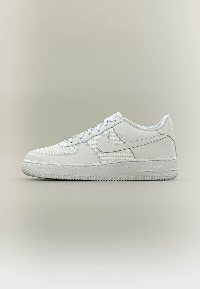 Λευκό sneaker Nike Air Force 1 χαμηλού προφίλ με πλέγμα και δερμάτινες επενδύσεις, εμφανιζόμενο από το πλάι σε απλό φόντο.