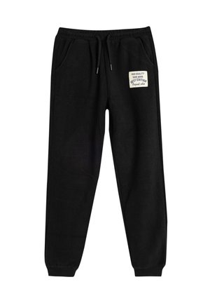 Zwarte sweatpants met een trekkoord in de taille, zijzakken en een fikkende patch met tekst op de linker dij; gemaakt van zachte, gestructureerde stof.