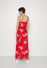 Vestido maxi vermelho com flores, com alças finas, apresentando padrões florais em rosa e verde. Tecido leve com um corte descontraído, design até ao tornozelo.