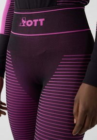 Leggings a vita alta in nero con strisce orizzontali rosa. Presentano il logo sulla vita. Realizzati in tessuto elastico e strutturato.
