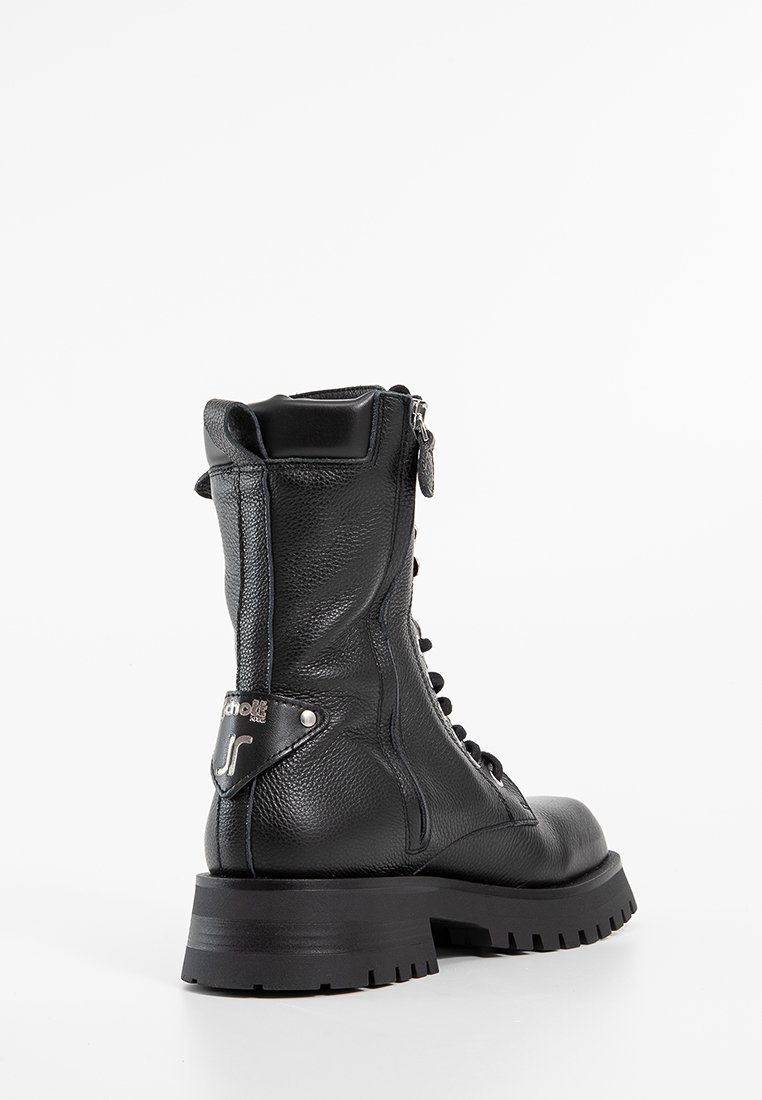 Bottine en cuir noir avec une finition texturée, devant à lacets, fermeture éclair sur le côté et semelle en caoutchouc épaisse. Détail en métal avec logo sur le talon.