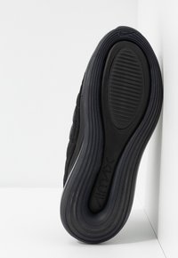 Semelle noire de basket avec un logo Air Max, montrée en gros plan sur un fond blanc d'angle.