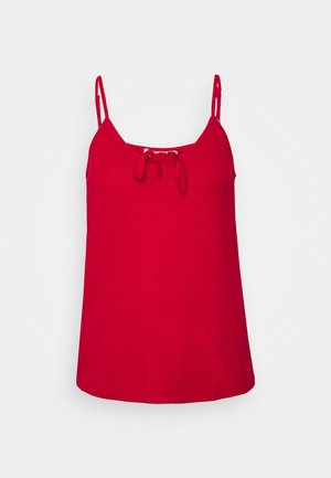 Rød ærmeløs camisole top med tynde stropper og en lille bundet sløjfe ved halsudskæringen på en ensfarvet baggrund.
