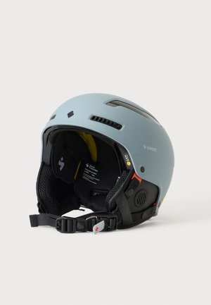 Casco da sport sulla neve azzurro chiaro con interno imbottito nero, fessure di ventilazione, cinturino regolabile per il mento e loghi del marchio ai lati.