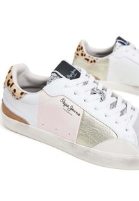 Baltie sporta apavi ar rozā, sudraba un bežām paneļiem, leopardu raksta akcentiem un teksturētām virsmām. Sasienama dizaina ar noapaļotu purngalu.