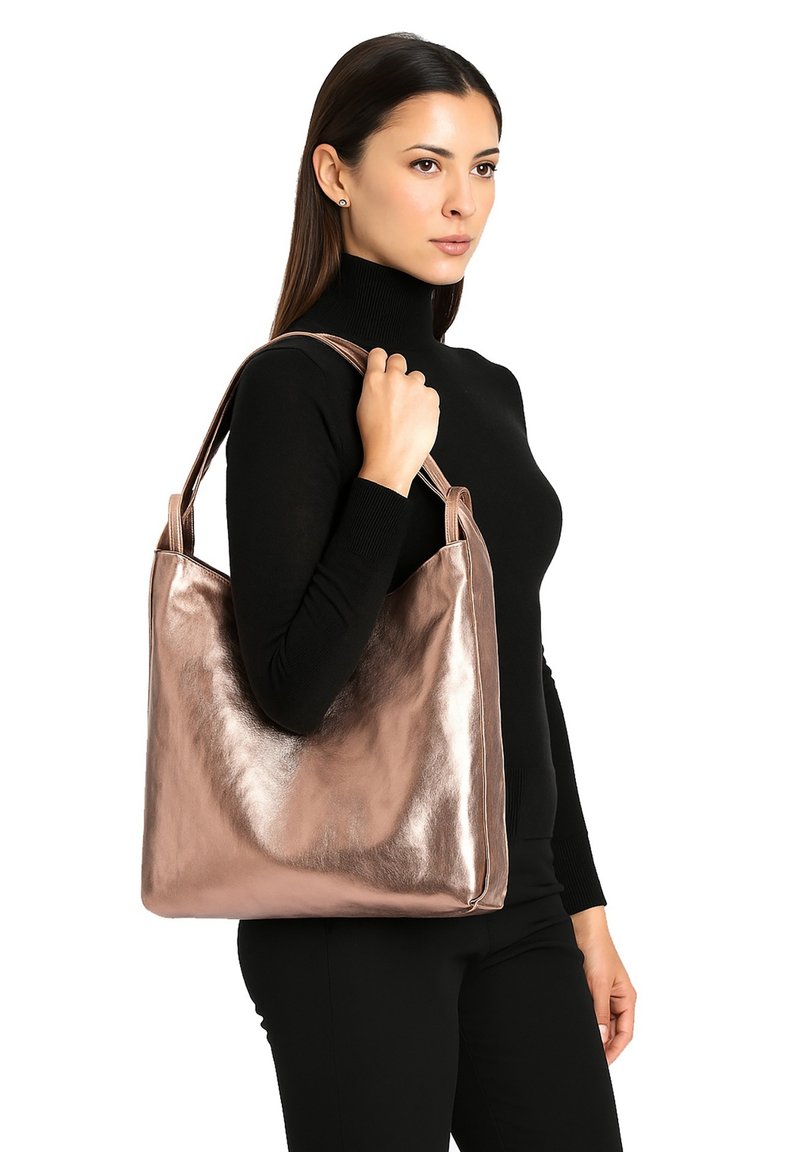 Metalen roségouden tote bag met een gladde textuur en gestructureerde vorm. Voorzien van dubbele handvatten en een minimalistisch ontwerp, ideaal voor veelzijdig gebruik.