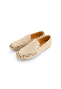 Suède loafers in licht beige, met een ingewikkeld gestikt patroon langs de teen en een strakke, minimalistische silhouet.
