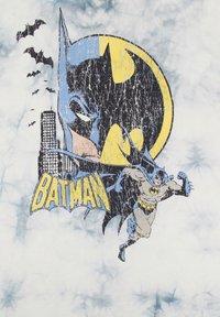 Camiseta gráfica con una ilustración desgastada de Batman en colores gris, amarillo y azul, con la palabra "BATMAN" en texto amarillo en negrita.