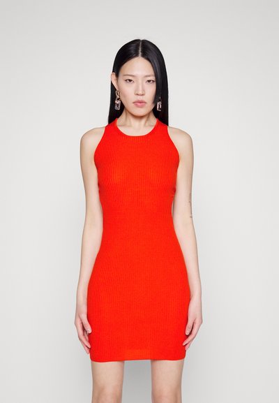 Κόκκινο πλεκτό φόρεμα με ριμπ ύφανση, ψηλό γιακά και μανίκια. Το ύφασμα έχει υφή και εφαρμοστή σιλουέτα.