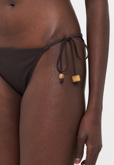 Brown bikini bottom featuring side ties with beads, smooth texture, and minimal coverage design. Accents include round and square wooden beads.
