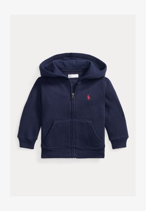 Navy modra zip-up jakna iz mehkega blaga, ki vključuje sprednji žep, rebrast rob in majhen rdeč logotip na levi strani prsi.