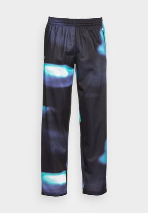 Pantaloni sportivi negri cu un finisaj lucios, având un model abstract albastru. Talie elastică și buzunare laterale cu fermoar pentru comoditate.