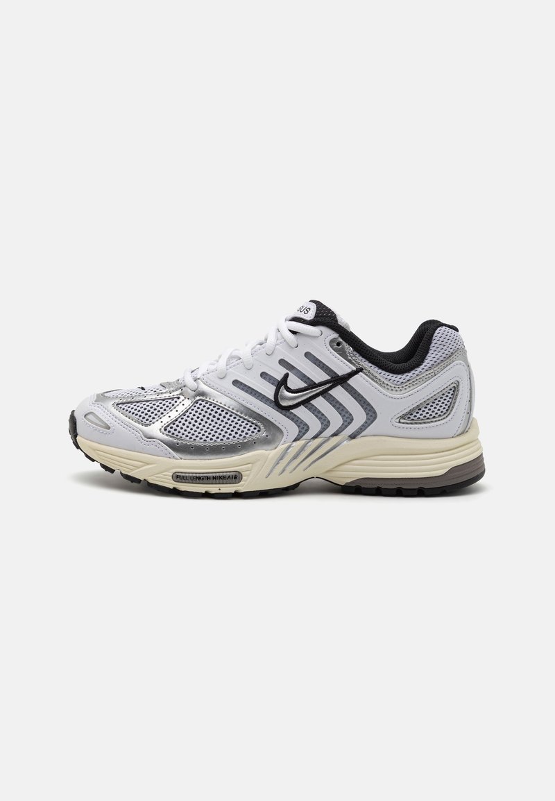 Chaussure de sport blanche avec des superpositions en mesh et en cuir, accents argentés, détails noirs et une semelle texturée pour l'adhérence. Présente un branding bien visible.