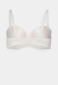 Reggiseno in lingerie bianca con coppe modellate, spalline regolabili e una fascia in pizzo. Tessuto liscio con chiusura a gancio sul retro.
