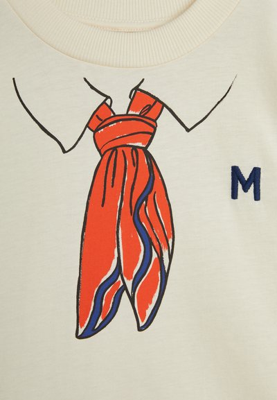 Cream fabric featuring a graphic illustration of a red scarf with blue and white stripes, knotted around a collar; embroidered letter "M" in navy.
