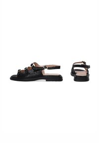 Sorte slingback sandaler med et tekstureret mønster, der har tre dekorative spænder, en flad sål og et åbent tådesign.