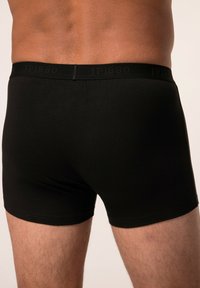Černé bavlněné boxerky s hladkou texturou, na kterých je diskrétní logo JP1880 na pásku. Navrženo pro pohodlí a dobře padnoucí střih.