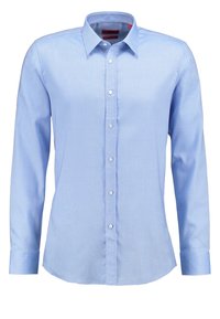 Chemise bleu clair à manches longues avec col pointu et poignets standards, présentée sans motifs ni logos.