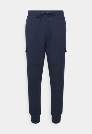 Marineblauwe joggingbroek met trekkoord in de taille, zijzakken met klep, knie naden en geribbelde boorden bij de enkels.