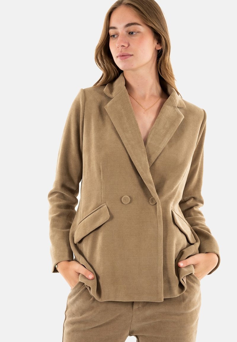 Blazer in corduroy khaki con design doppiopetto, rever a scudo, tasche laterali e tessuto testurizzato.