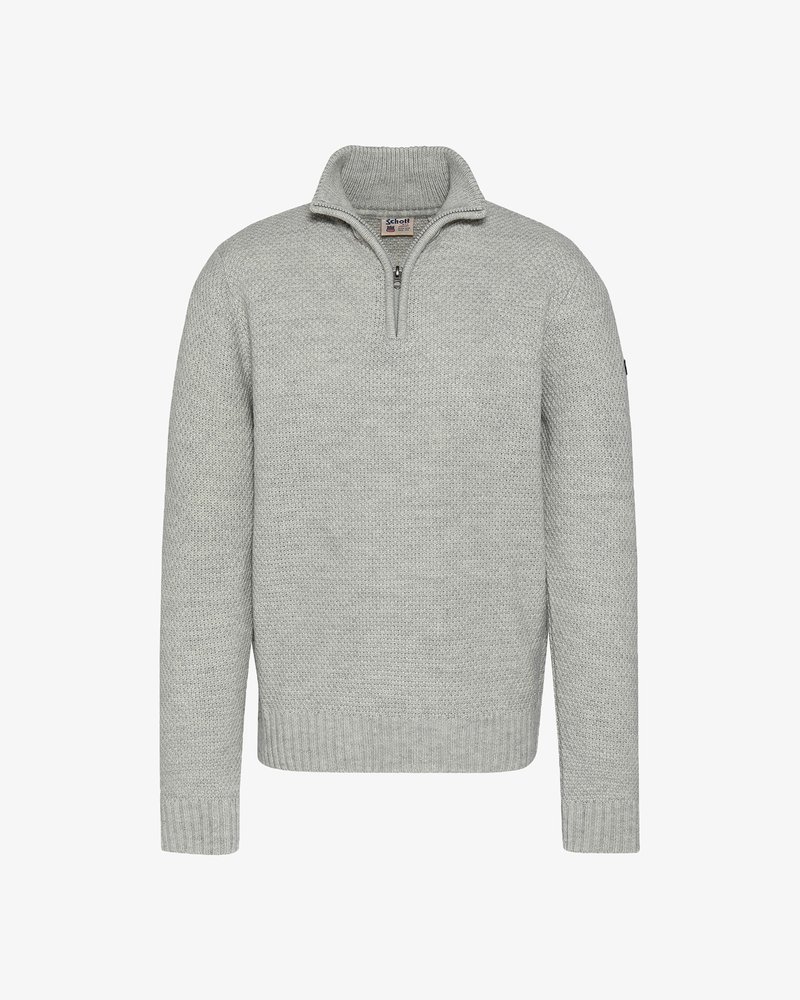 Szary sweter dzianinowy z kołnierzem zapinanym na zamek do ćwiartki, ściągaczami przy mankietach i dole, teksturowaną tkaniną oraz małym logo na lewym rękawie.