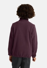 Pull en polaire violet foncé avec un col montant, présentant une texture lisse et un ourlet légèrement froncé à la taille.