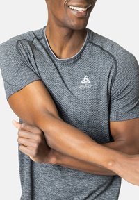 Grijs sportshirt met korte mouwen van textuurstof, ronde halslijn en Odlo-logo op de linkerborst. Glad, lichtgewicht materiaal.