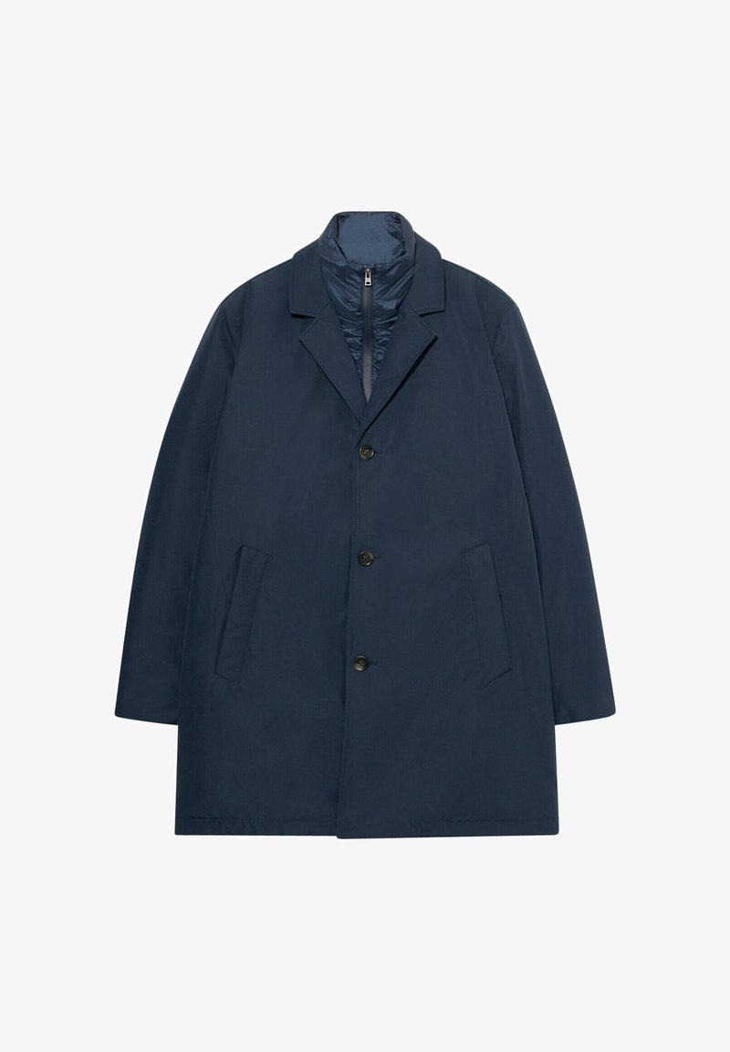 Navy blauwe jas van lichtgewicht stof, met een geknipte kraag, vijf knopen en zijzakken. De binnenvoering is gewatteerd.