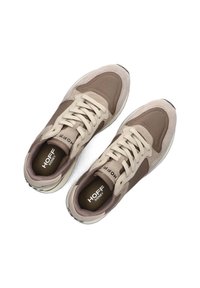 Beige und braune Sneakers aus Textil und Wildleder, mit gepolstertem Schaft, Schnürdesign und Gummisohle mit strukturierten Akzenten.