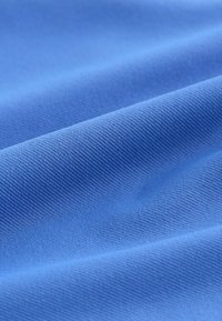 Tela azul con una textura suave y un patrón acanalado fino, que muestra un color uniforme y una caída flexible.