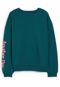 Sweat-shirt à manches longues couleur sarcelle avec poignets et ourlet côtelés, avec un texte rose "Another Day" imprimé verticalement sur la manche gauche.