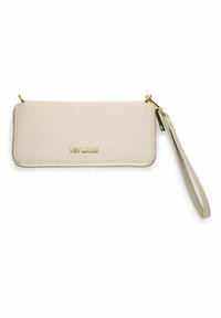 Portefeuille en cuir beige avec surface texturée, fermeture éclair et quincaillerie dorées, équipé d'une lanière et du nom de la marque en relief.