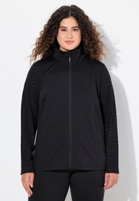 Svart zip-up jacka med hög krage, med randiga mönster på ärmarna och ett lätt, strukturerat tyg.