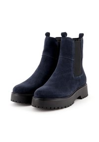 Stivaletti in camoscio blu navy con pannelli laterali elastici e linguette, dotati di una spessa suola in gomma nera e dettagli testurizzati.