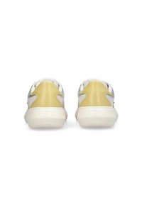 Baskets blanches et jaunes avec une surface texturée, un contrefort de talon lisse, et une légère courbure sur les côtés pour un détail de design supplémentaire.