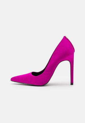 Fuksia ruskind høje hæle med spids tå og et udskåret design i siderne. Har en slank silhuet og en sort sål.