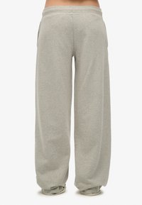 Grijze sweatpants gemaakt van zachte stof, met een relaxte pasvorm, een elastische tailleband, zijzakken en taps toelopende boorden aan de onderkant.