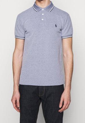 Polo shirt gris à manches courtes avec un col, patte de boutonnage à trois boutons et accents rayés bleu marine sur le col et les manches. Détail de logo subtil.