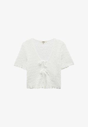 Top corto bianco a maniche corte con texture, scollatura a V e due chiusure frontali a cravatta con piccoli dettagli di perle.
